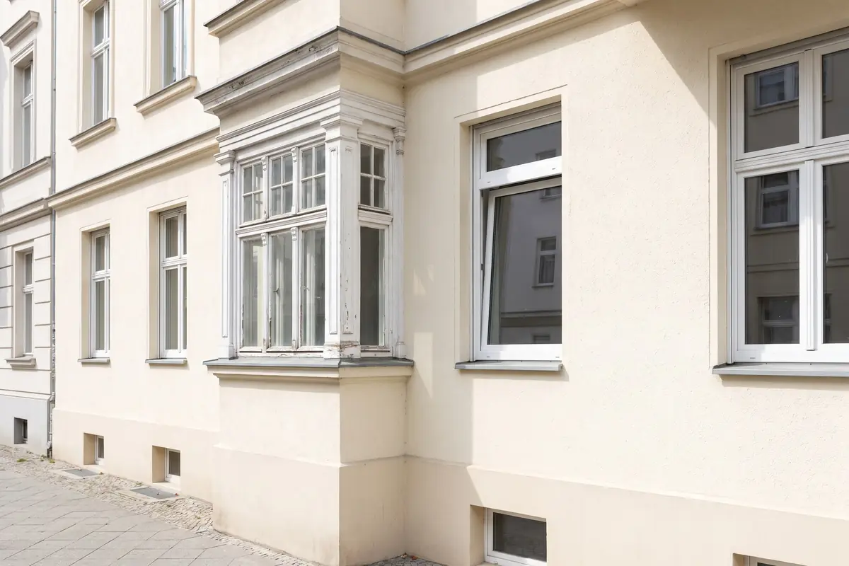 Altes Holzfenster neben modernem Isolierglasfenster an einer Altbaufassade